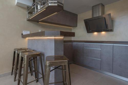 uma cozinha com bancos e um balcão com micro-ondas em MORALEJA SUPREME PRIVATE LOFT - COLLECTION III em Alcobendas
