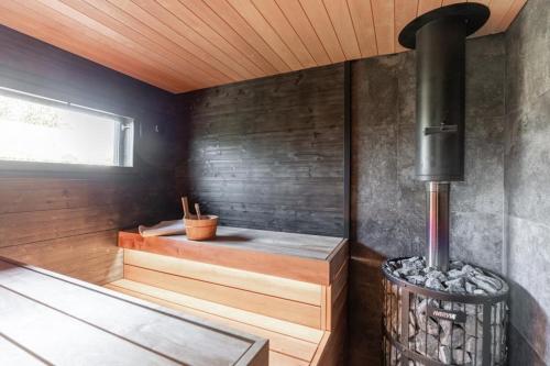 una sauna con estufa de leña en una habitación en Villa Mommo II, en Rovaniemi