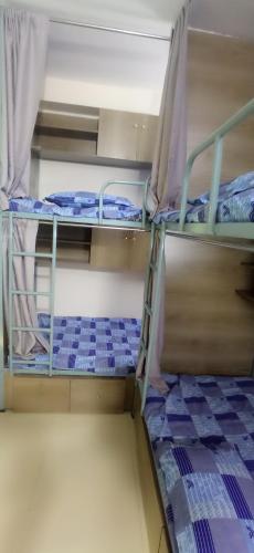 two bunk beds in a room with purple sheets at Smart Hostel in Dhaka
