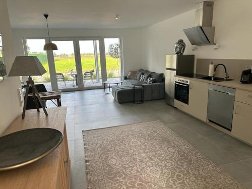 eine Küche und ein Wohnzimmer mit einem Sofa und einem Tisch in der Unterkunft Hof Busen Landhaus Ap. in Mönchengladbach