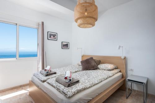 a bedroom with a bed with a view of the ocean at Bahia cozy ocean view suite in Puerto de Santiago