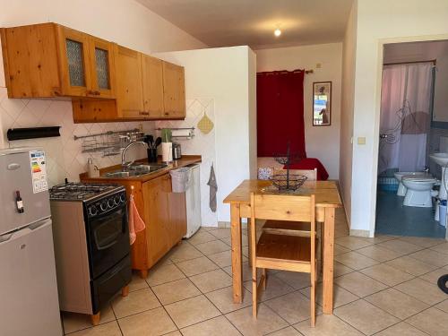 a kitchen with a table and a stove and a sink at Apto Martins - Residencial Inês N 23 in Vila do Porto