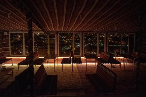 a room with chairs and a view of the city at night at Twilight Hotel Petra in Wadi Musa