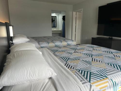 a bedroom with two beds and a flat screen tv at Studio 6 Tulsa OK Central in Tulsa