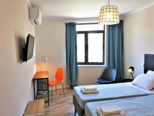 Un dormitorio con una cama, un escritorio y una silla. en Porto Ville Touring, en Oporto