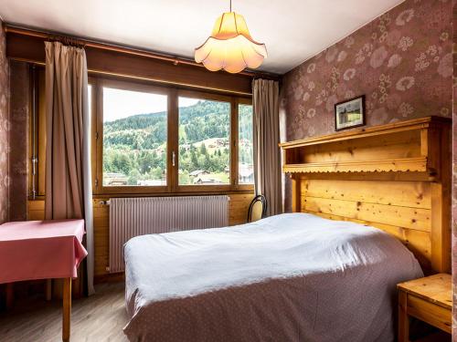 une chambre avec un lit et une grande fenêtre dans l'établissement Appartement 2 chambres centre village - Proche pistes, cheminée, animaux admis - FR-1-437-41, à La Clusaz