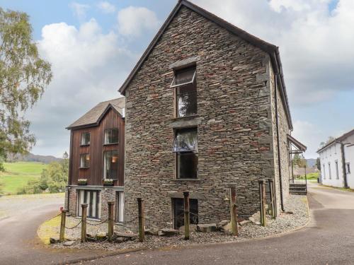 an old brick building on the side of a road at Le Chalet in Elterwater