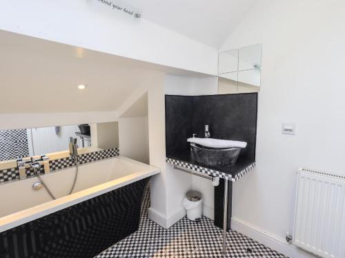 a bathroom with a sink and a bath tub at Le Chalet in Elterwater