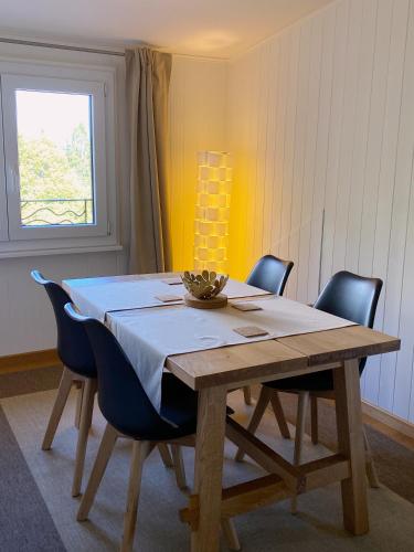 ArzierにあるBnB La Clemonieのダイニングルーム(椅子、白いテーブルクロス付)