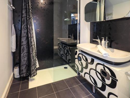 a black and white bathroom with a sink and a shower at Le Chalet in Elterwater