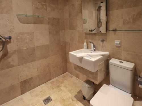 a bathroom with a white toilet and a sink at Le Chalet in Elterwater