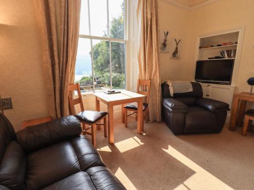 a living room with a couch and a table and a window at Easedale in Grasmere