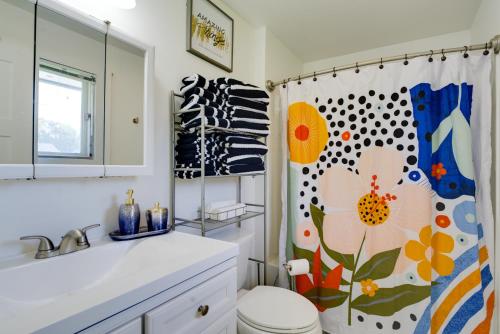a bathroom with a toilet and a shower curtain at Rustic Retreat in Spokane Valley with Cozy Fireplace in Spokane Valley