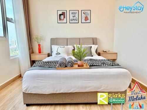 a bedroom with a large bed with a tray on it at Amber Cove Impression City By Heystay Management in Melaka