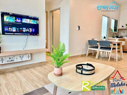 a living room with a flat screen tv on the wall at Amber Cove Impression City By Heystay Management in Melaka