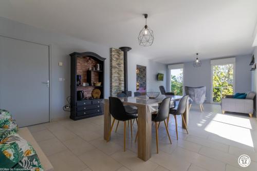 a dining room and living room with a table and chairs at Tri-O-Bois in Thianges