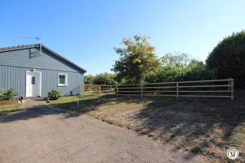 a barn with a fence next to a field at Tri-O-Bois in Thianges