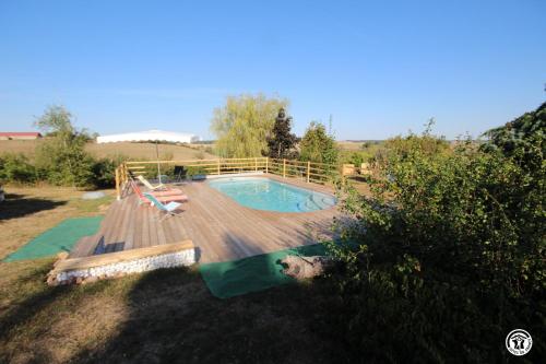 a swimming pool on a wooden deck with a swimming poolvisor at Tri-O-Bois in Thianges