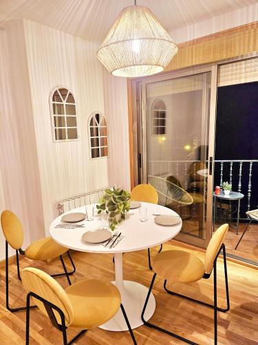 a dining room with a white table and chairs at apartamentcastrotuy in Tui