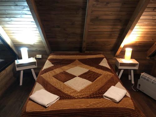 uma cama grande num quarto de madeira com duas velas em Cabaña la encantadora em Salta