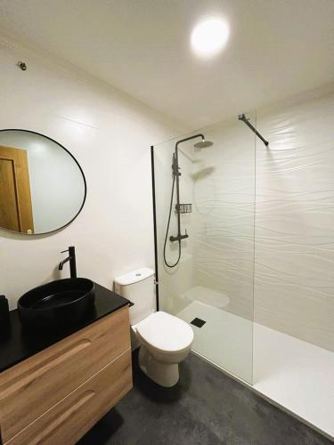 a bathroom with a toilet and a glass shower at apartamentcastrotuy in Tui