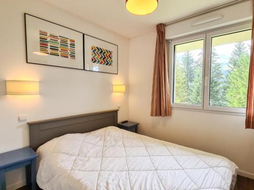 une chambre avec un lit et deux fenêtres dans l'établissement Appartement 2 pièces confortable, balcon, centre station, parking couvert, Flaine Forêt - FR-1-425-161, à Flaine