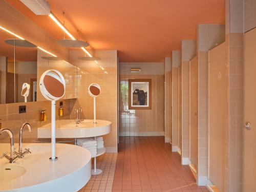 a bathroom with two sinks and two mirrors at CityHub Rotterdam in Rotterdam