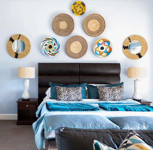 a bedroom with a bed with blue pillows and hats on the wall at Fordoun Hotel and Spa in Nottingham Road