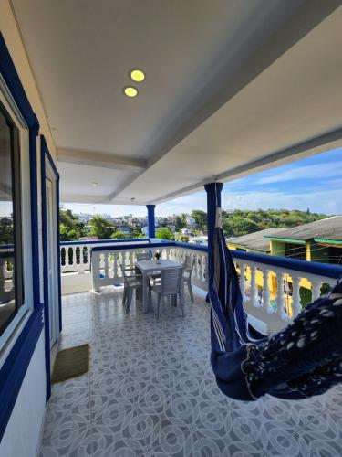 eine Hängematte auf einem Balkon mit einem Tisch und Stühlen in der Unterkunft Apartamentos SurOeste in San Andrés