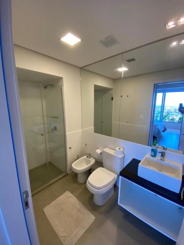 Un baño con inodoro, lavabo y ducha. en Edificio 01 Mburucuya, en Asunción