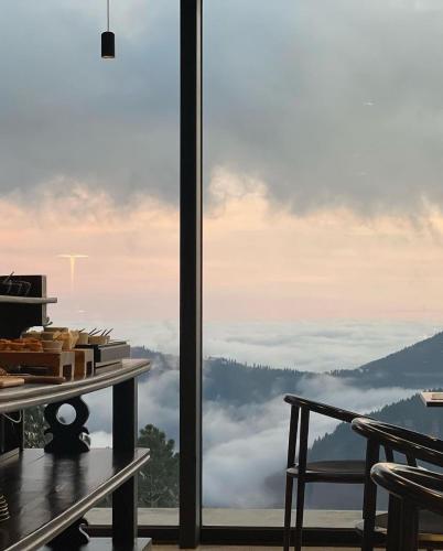 a room with a large glass window with a view of clouds at Casa de São Lourenço - Burel Panorama Hotel - member of Design Hotels in Manteigas