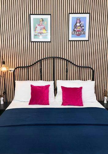 ein Schlafzimmer mit einem Bett mit zwei roten Kissen in der Unterkunft Fifteen Apartment in Neapel
