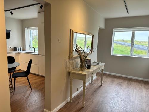 a room with a table with a vase of flowers on it at Urriðafoss Waterfall Villa in Selfoss