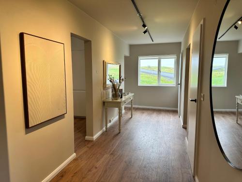 an empty hallway with a table and a mirror at Urriðafoss Waterfall Villa in Selfoss