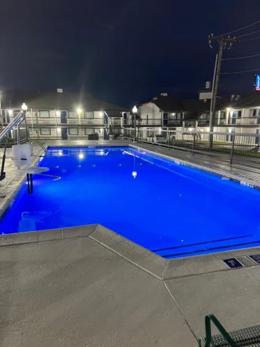 a large blue swimming pool at night at Studio 6 Tulsa OK Central in Tulsa