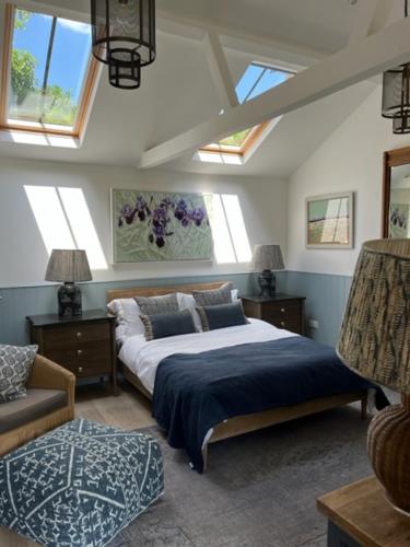 1 dormitorio con cama, sofá y ventanas en The Garden Studio, en Dorking