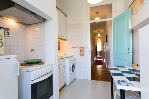 a kitchen with a washer and dryer and a hallway at Principe Real Orange tree w/ view 3 bedrooms flat! in Lisbon