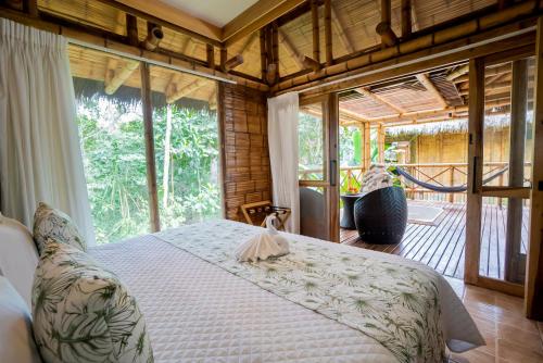 a bedroom with a bed and a large window at La Selva Eco-Lodge & Retreat in Providencia