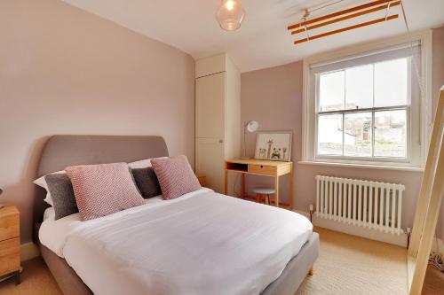 um quarto com uma cama branca e uma janela em Pass the Keys Perfectly presented centrally located townhouse em Royal Tunbridge Wells