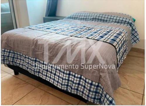 Una cama con una manta encima. en TMX HOSTAL, en Puerto Escondido