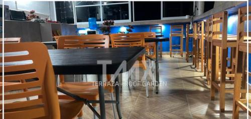 uma sala de jantar com mesas e cadeiras de madeira em TMX HOSTAL em Puerto Escondido
