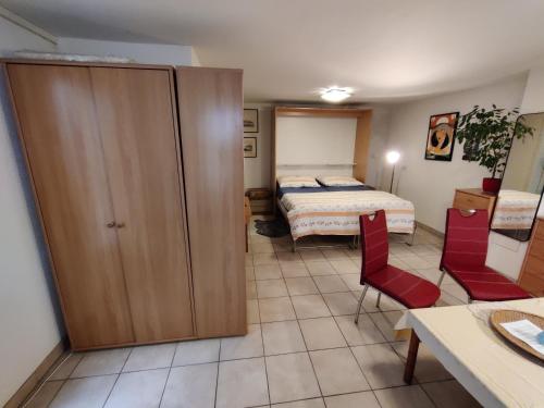 una piccola camera con un letto e due sedie rosse di Studio with private bathroom a Ginevra