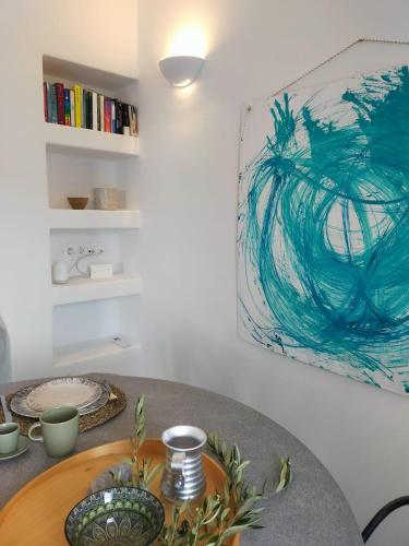 a dining room table with a painting on the wall at Amorgos Elegant Houses, 6 Villas in Amorgos