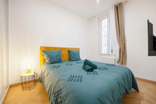 圖盧茲的住宿－Le Verdoyant - T2 moderne - proche Gare，一间卧室配有一张带蓝色床单的大床和窗户。