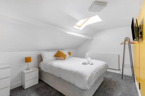 a white bedroom with a bed and a skylight at Jefferson 4 Bed, 5 Guests in Goole