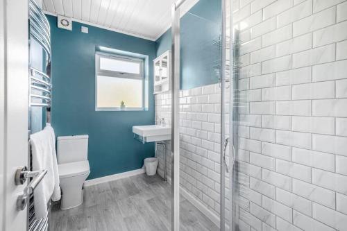 a blue bathroom with a toilet and a sink at Jefferson 4 Bed, 5 Guests in Goole
