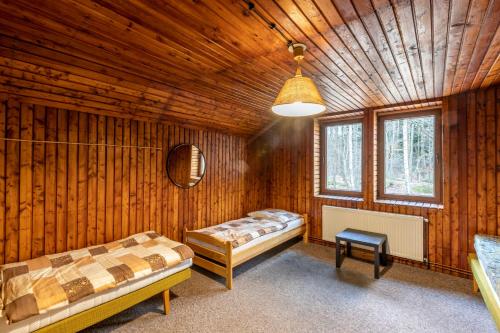 CHATA JIZERKY ŠOLCŮV RYBNÍK في Raspenava: غرفة نوم بسريرين في غرفة خشبية