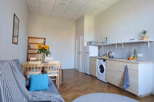 kuchnia i salon z kanapą i stołem w obiekcie DReAM Post Aparthotel w Krakowie