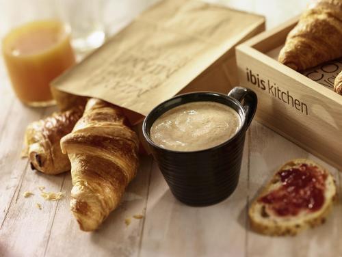 a table with a cup of coffee and a box of pastries at ibis Marseille Centre Gare Saint Charles in Marseille