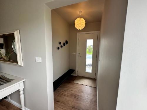 an empty hallway with a door and a chandelier at Urriðafoss Waterfall Villa in Selfoss